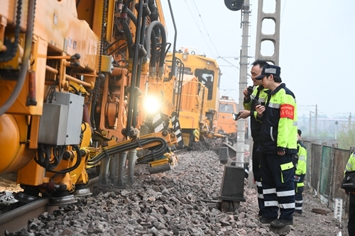 圖為4月14日,一名青年職工在師傅的帶領(lǐng)下對(duì)陜西省渭南市隴海線太要站至豫靈站區(qū)間的搗固作業(yè)進(jìn)行盯控。祁映辰 攝.JPG